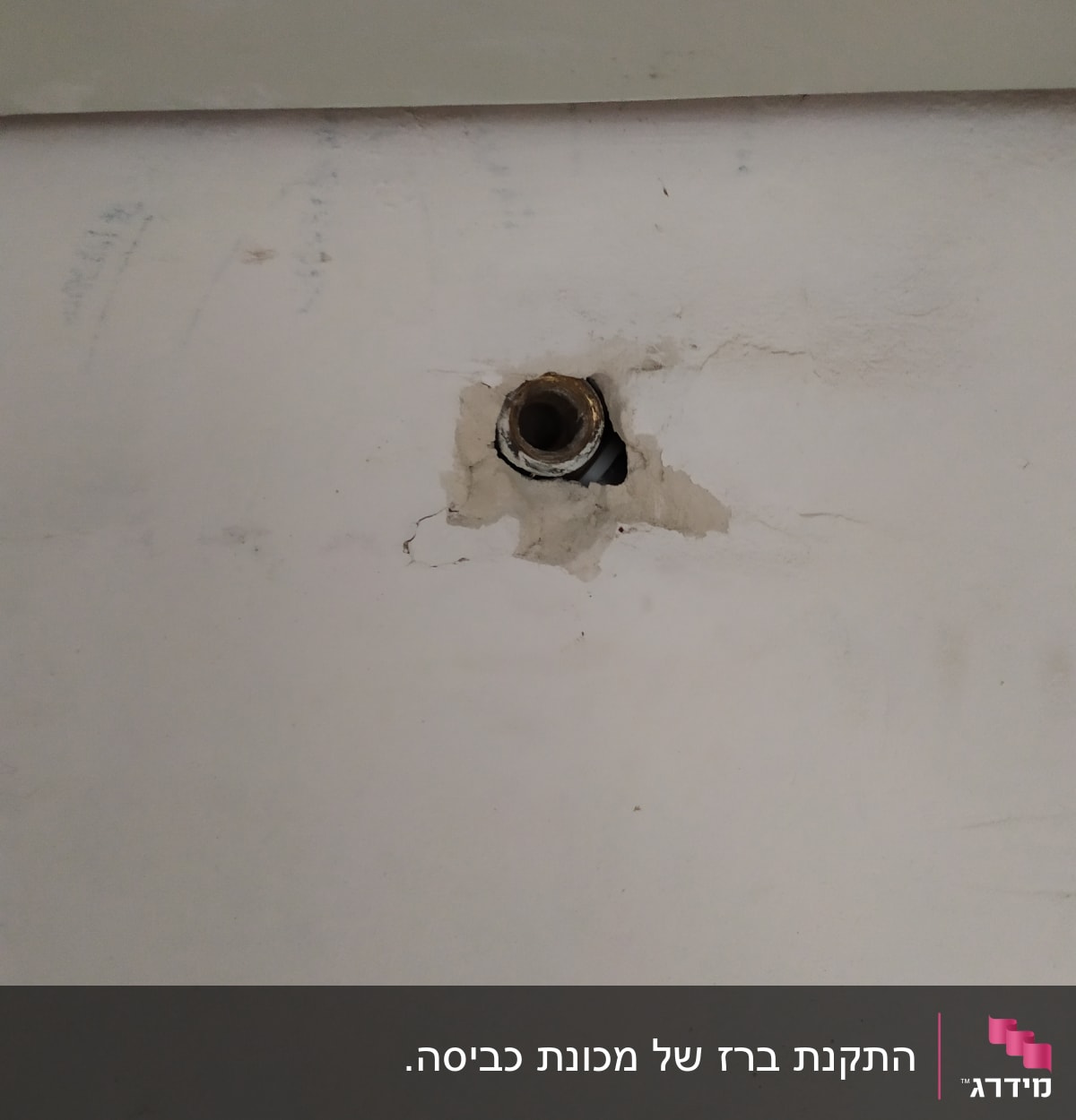 צינור מים חשוף בקיר עם סדקים מסביב
